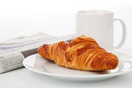 A croissant for breakfast, with newspaper