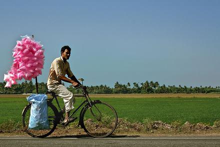 a candy man selling cotton candy at a village side