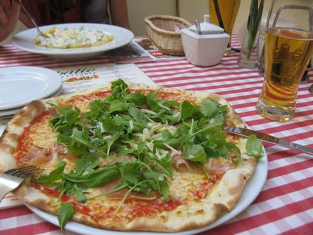 Pizza z szynką parmeńską, rukolą i parmezanem oraz przepysznym sosem pomidorowym